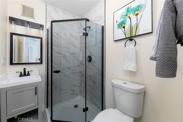 bathroom with a shower with door, vanity, and toilet