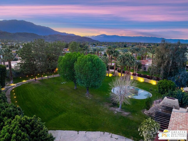 aerial view at dusk featuring a mountain view