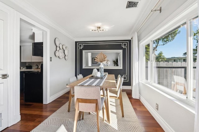 dining area featuring crown molding and dark wood-type flooring