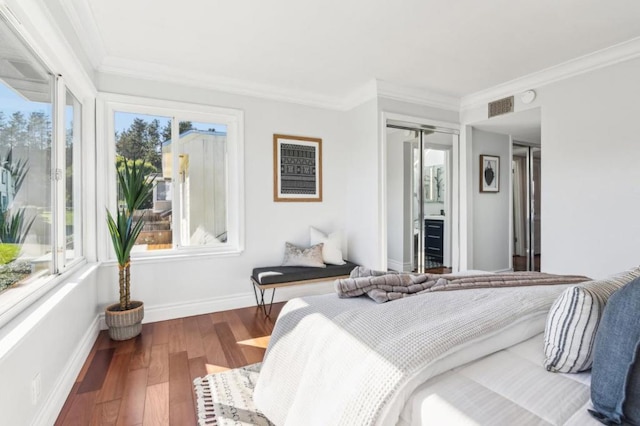 bedroom featuring hardwood / wood-style flooring, crown molding, and multiple windows