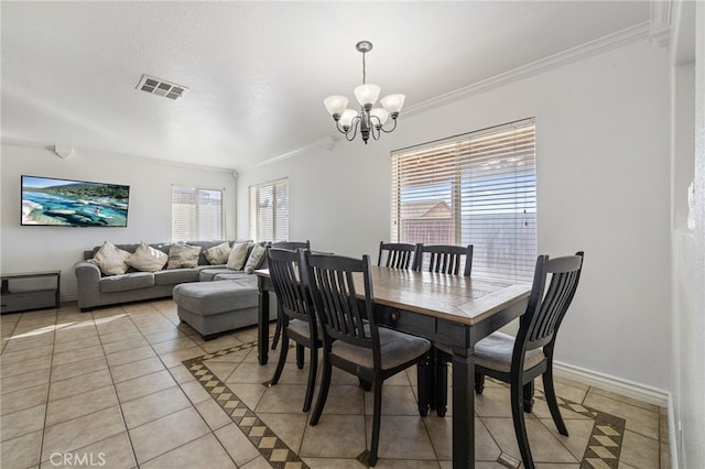 tiled dining space with crown molding and an inviting chandelier