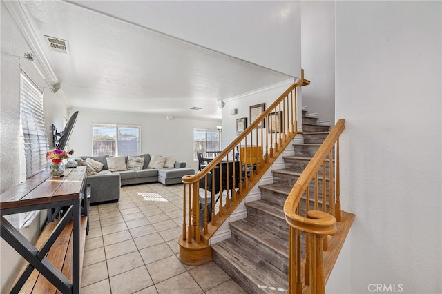 stairs featuring tile patterned flooring and ornamental molding