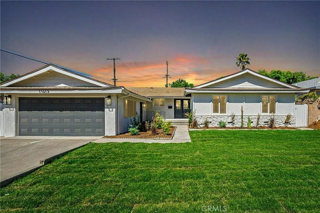 ranch-style house with a yard and a garage