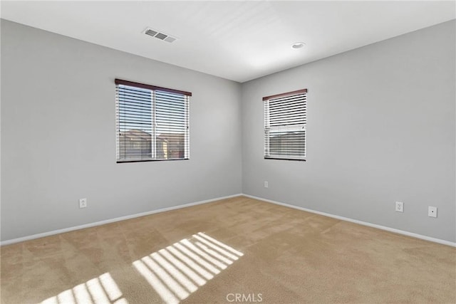 unfurnished room featuring light carpet