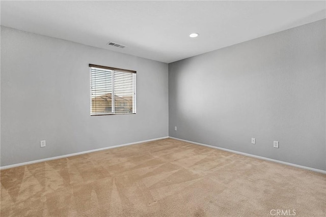 spare room featuring light colored carpet