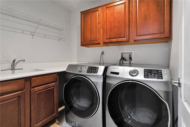 washroom with sink, washing machine and clothes dryer, and cabinets