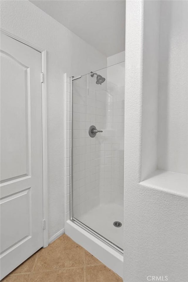 bathroom featuring tile patterned flooring and an enclosed shower