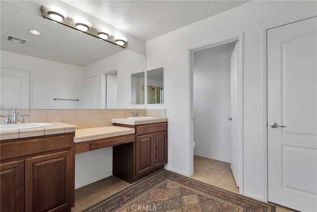 bathroom with toilet, backsplash, and vanity