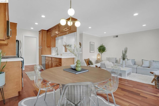 dining space featuring sink and light wood-type flooring