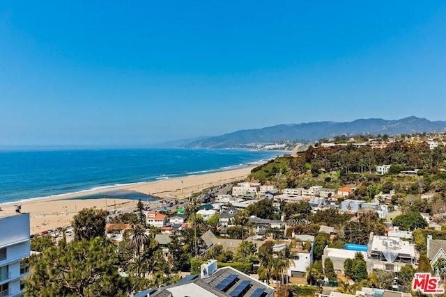 birds eye view of property featuring a water and mountain view and a view of the beach