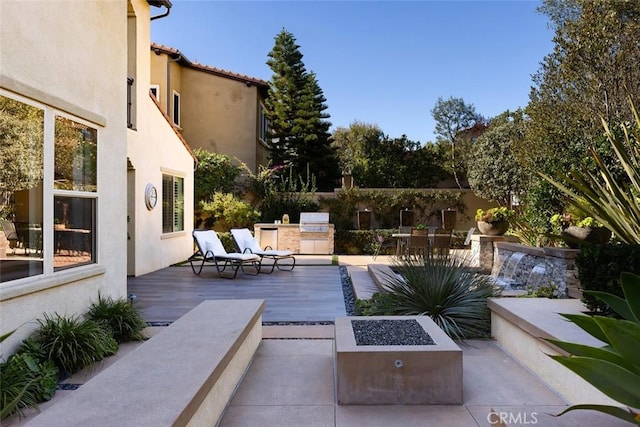 view of patio / terrace featuring exterior kitchen and a fire pit