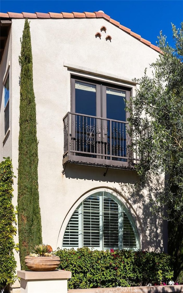 back of property with a balcony and french doors