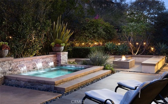 view of swimming pool featuring a patio area, an in ground hot tub, pool water feature, and a fire pit