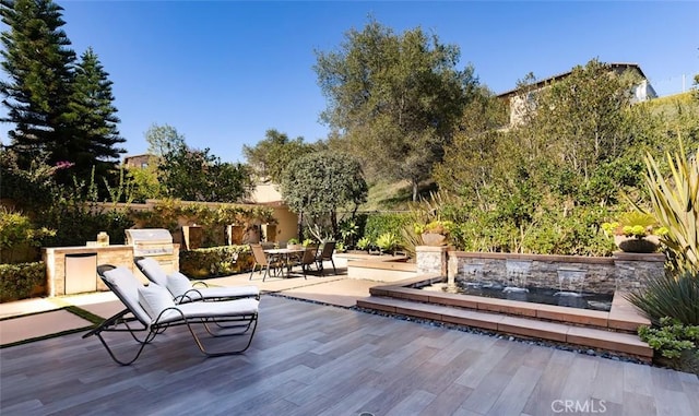 wooden terrace with a grill and a patio area