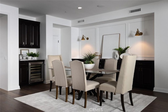 dining room featuring indoor bar, wine cooler, and dark hardwood / wood-style floors