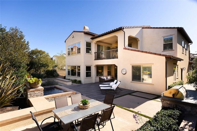 back of house with a balcony, a patio, and area for grilling