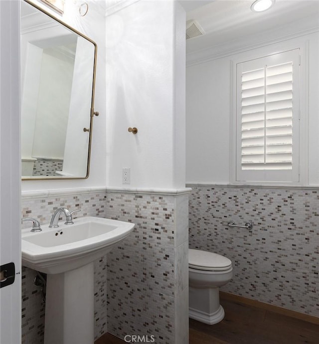 bathroom with tile walls, sink, and toilet