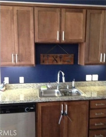 kitchen with sink, dishwasher, and light stone counters