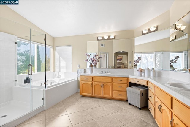 bathroom with a wealth of natural light, lofted ceiling, and tile patterned floors