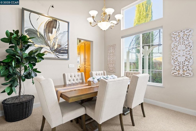 carpeted dining room with a chandelier