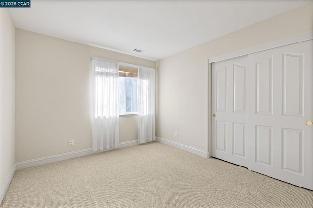 unfurnished bedroom featuring a closet and light carpet