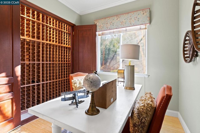 wine cellar with ornamental molding, plenty of natural light, and hardwood / wood-style flooring