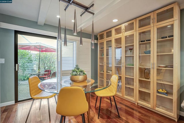 dining area with dark wood-type flooring and beamed ceiling