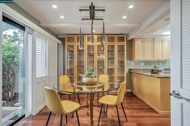 dining space featuring beam ceiling and dark hardwood / wood-style flooring