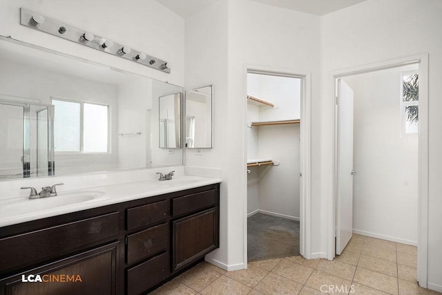 bathroom with an enclosed shower, vanity, and tile patterned flooring