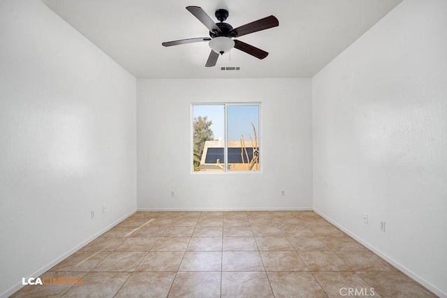 tiled empty room featuring ceiling fan