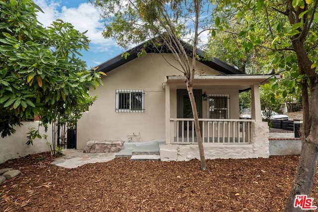 back of property featuring covered porch