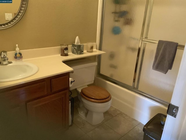 full bathroom with toilet, bath / shower combo with glass door, tile patterned flooring, and vanity