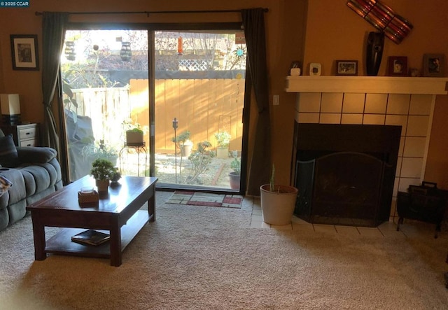 carpeted living room featuring a tiled fireplace