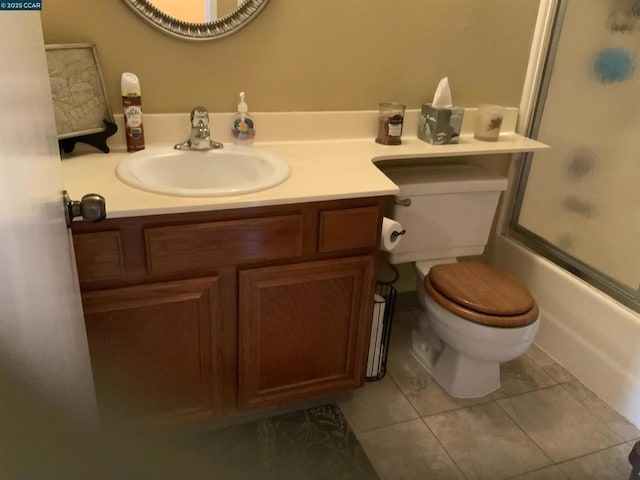 full bathroom featuring tile patterned floors, bath / shower combo with glass door, toilet, and vanity