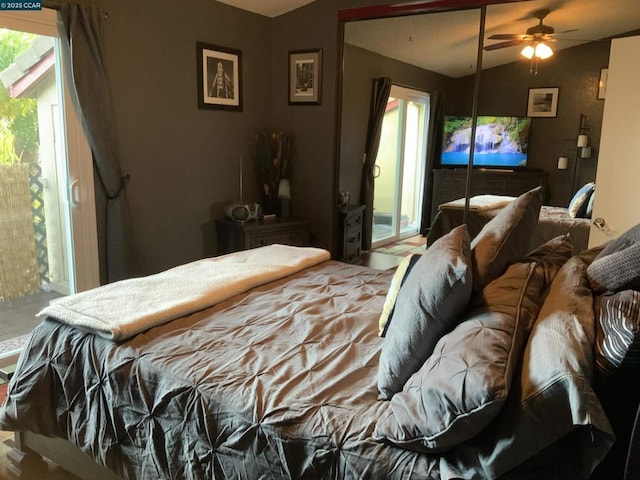 bedroom featuring ceiling fan, access to exterior, multiple windows, and vaulted ceiling