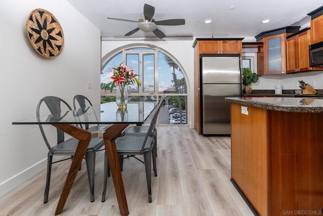 dining room with ceiling fan and light hardwood / wood-style flooring