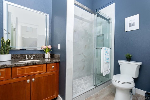 bathroom featuring toilet, an enclosed shower, hardwood / wood-style floors, and vanity