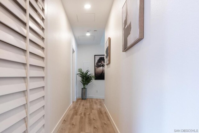 hallway with light hardwood / wood-style floors