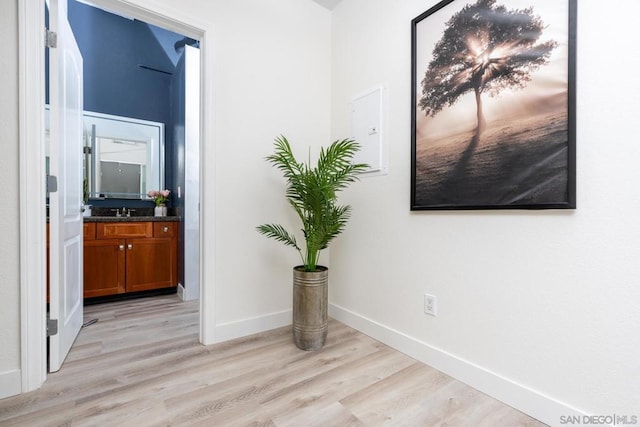 hallway with sink and light hardwood / wood-style floors