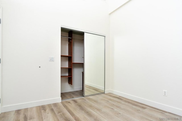 unfurnished bedroom with a closet and light hardwood / wood-style floors