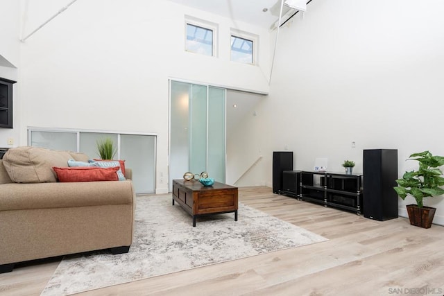 living room featuring a high ceiling and light wood-type flooring