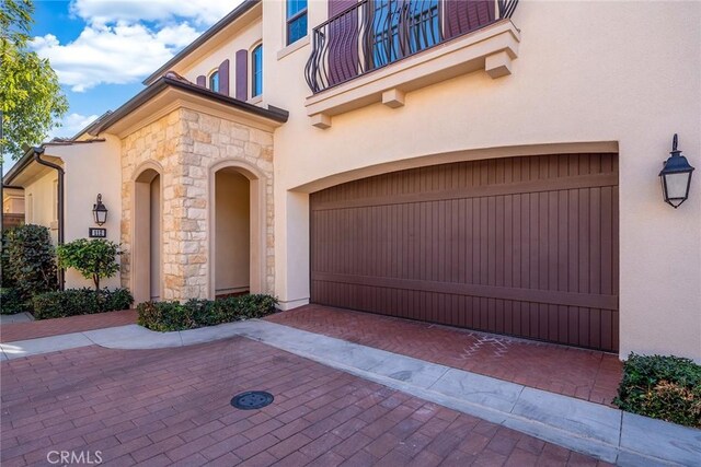 property entrance with a balcony and a garage