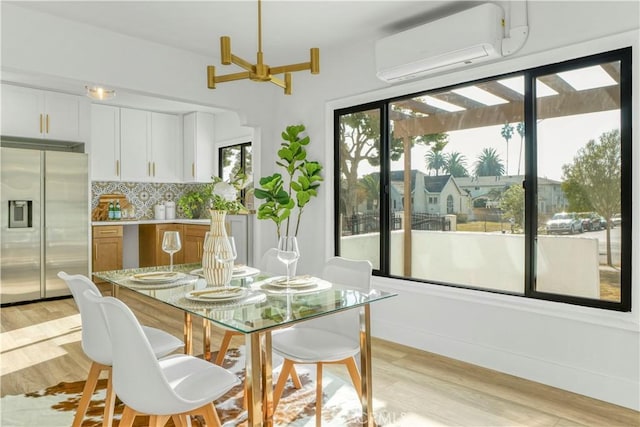 dining room featuring light hardwood / wood-style flooring and a wall mounted AC