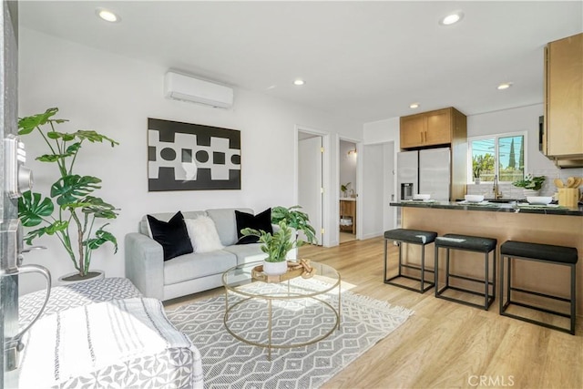 living room featuring a wall unit AC and light hardwood / wood-style flooring