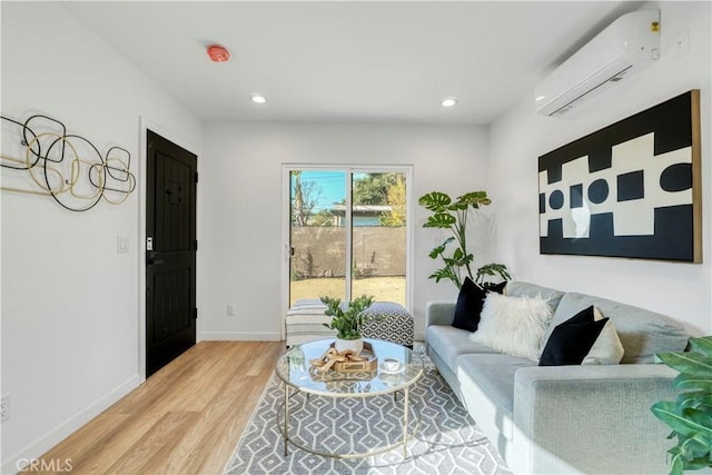 living room with light hardwood / wood-style floors and an AC wall unit