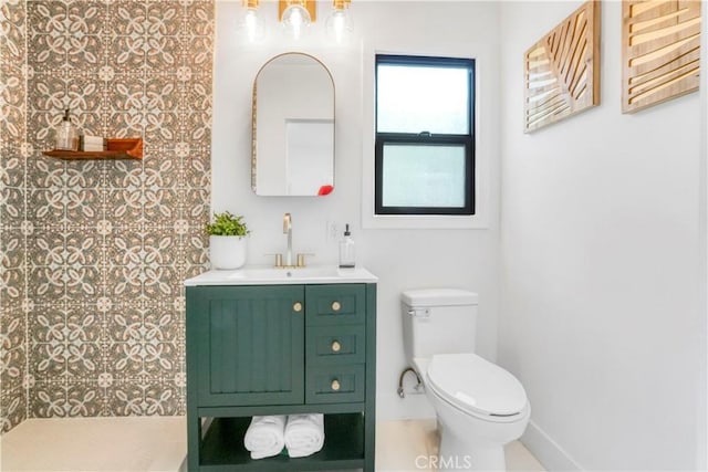 bathroom featuring toilet, a shower, and vanity