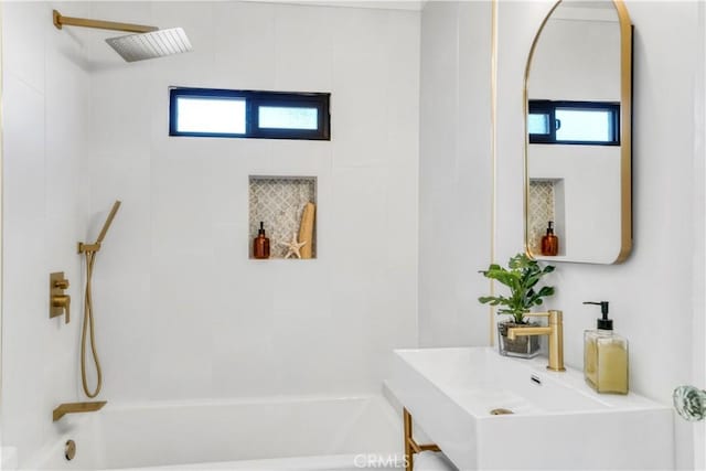 bathroom with sink, tiled shower / bath combo, and plenty of natural light