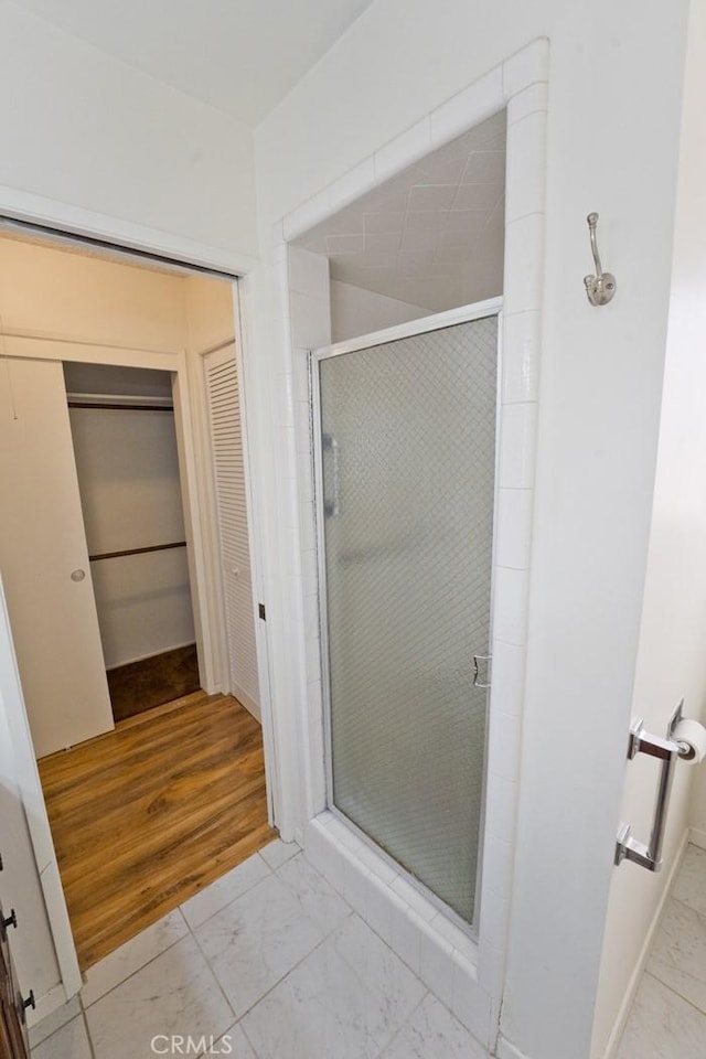 bathroom featuring an enclosed shower and hardwood / wood-style floors