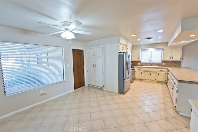 kitchen with ceiling fan, stainless steel appliances, backsplash, and sink