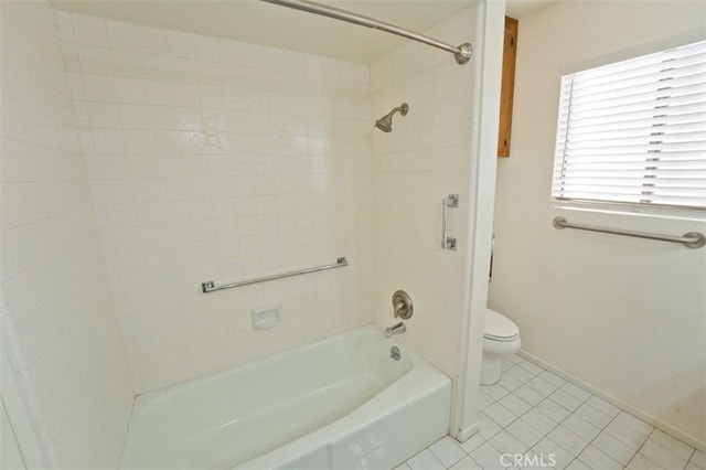 bathroom with toilet, tile patterned flooring, and tiled shower / bath combo